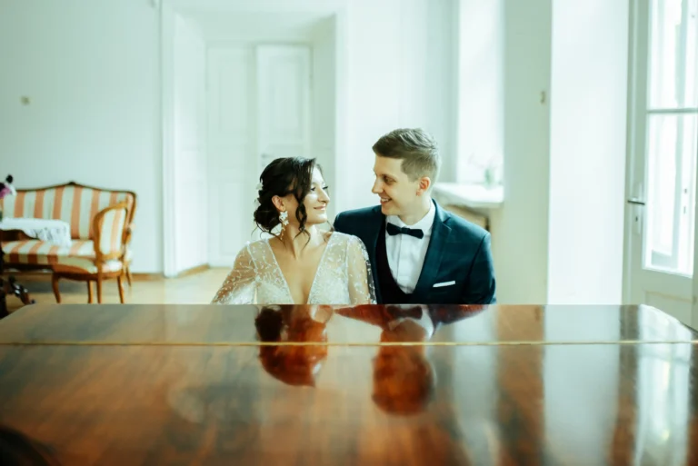Para młoda przy stole w jasnym wnętrzu – fotografia ślubna