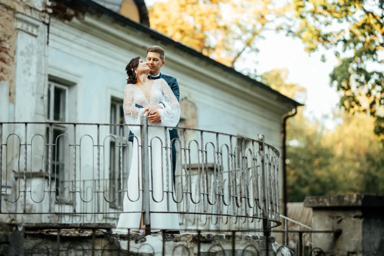 Para młoda na balkonie starego dworku – sesja ślubna